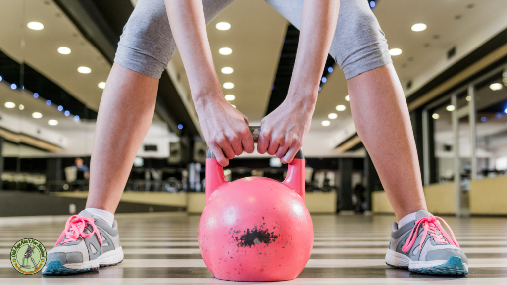 A female about to swing a pink kettle-bell