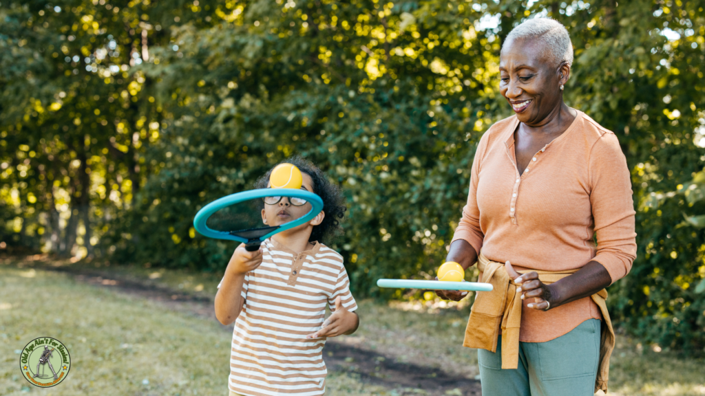 Grandmother and grandson in a park playing keepsy uppies with tennis racquets